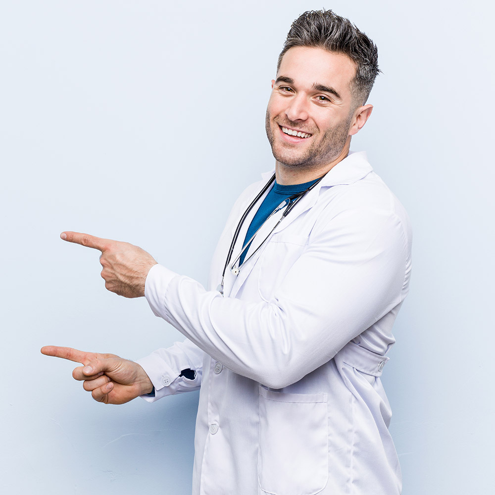 Young handsome doctor man excited pointing with forefingers away.
