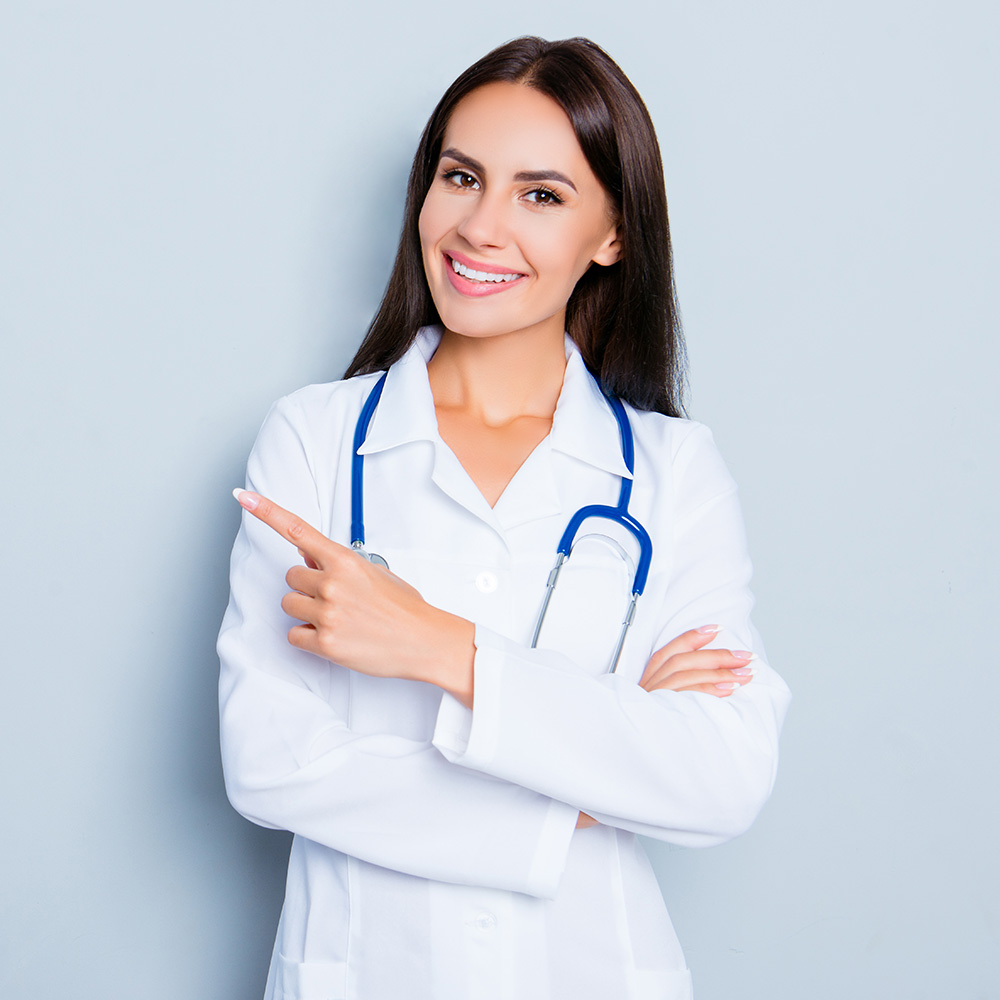 Smiling happy doctor pointing with finger on blue background