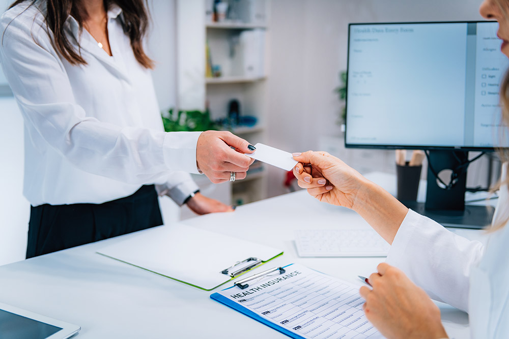 woman handing over her medical insurance card