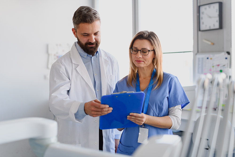 Doctor and female nurse looking at test results in clipboard