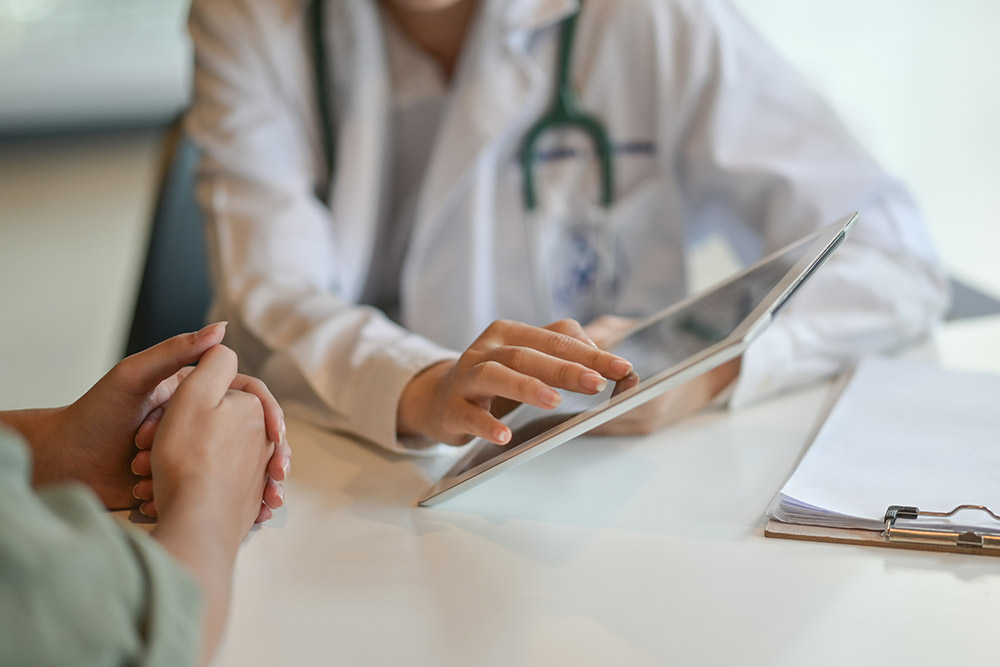 Shot of a doctor showing a patient some information on a digital tablet