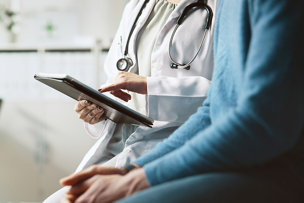 Hands, doctor and patient with tablet, explain and conversation with feedback for diagnosis. People, closeup and medical with professional, man and tech for online results, review illness and report.