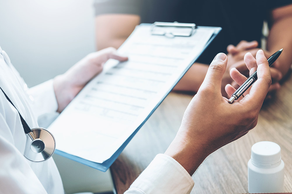 Doctors and patients sit and talk. At the table near the window in the hospital.