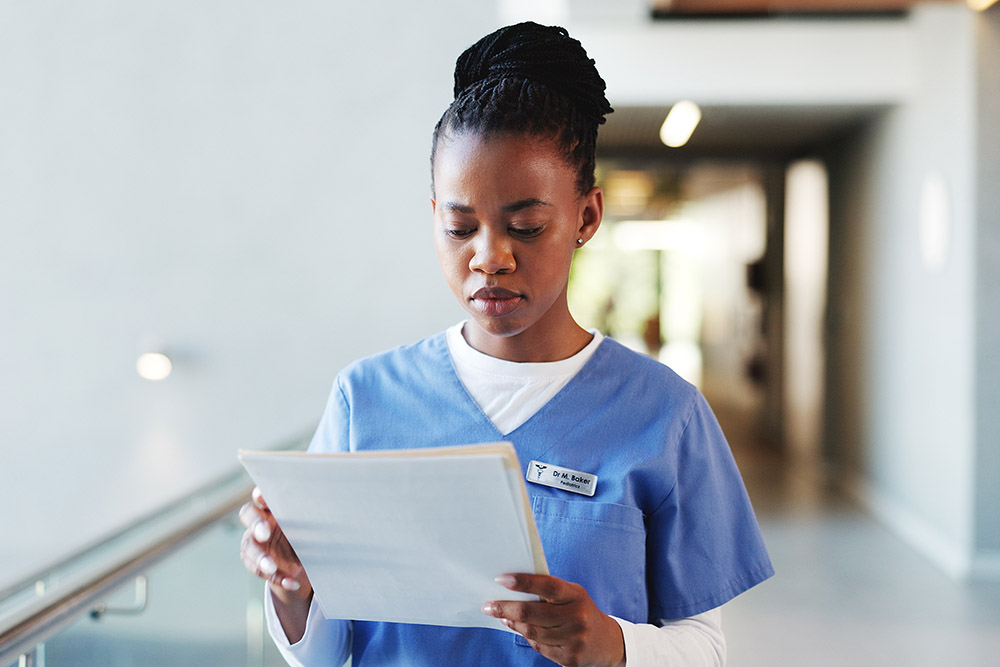 Nurse, reading and woman with documents, hospital and info for medical diagnosis, serious and report. Review, patient records and black person with paperwork for treatment plan, healthcare and file.