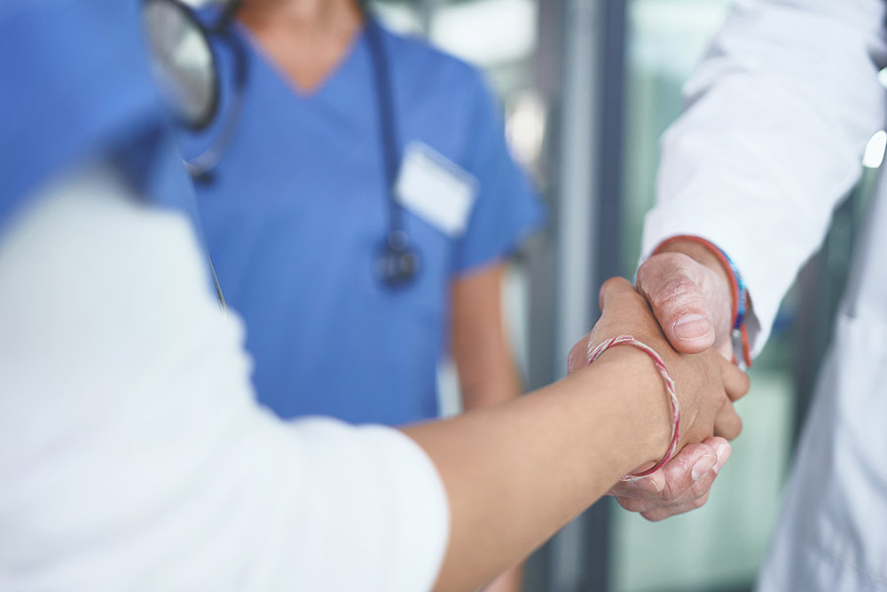 nurse and doctor shaking hands
