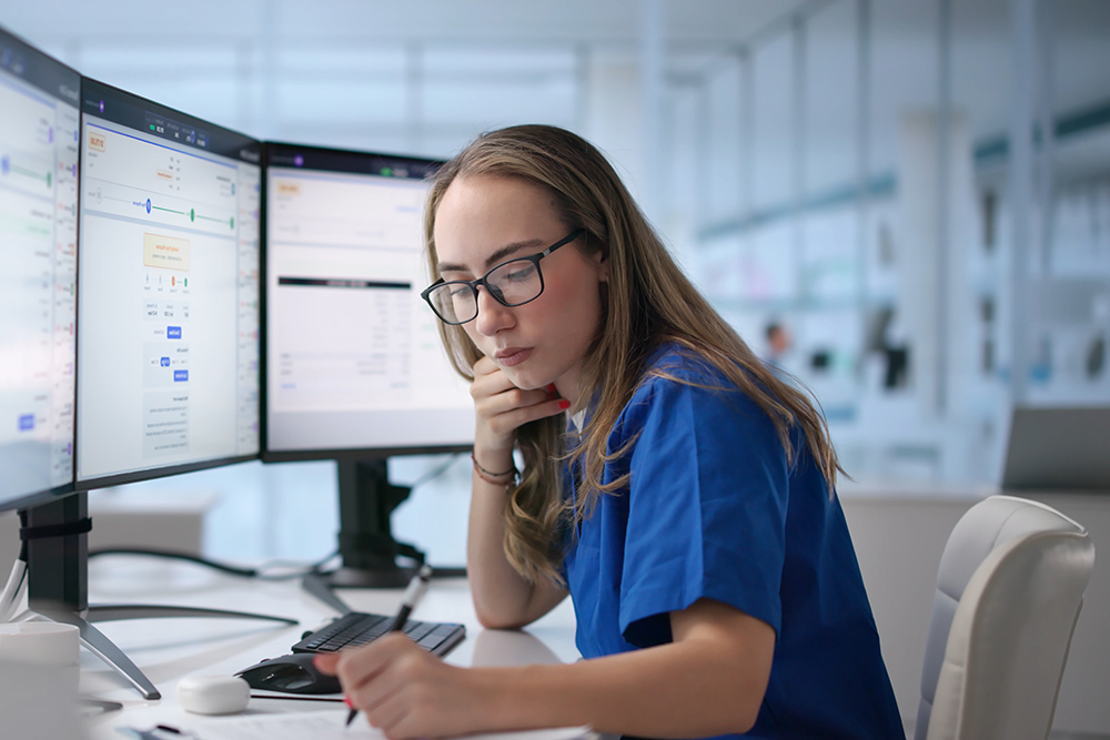 Woman Reviews Healthcare Claims On Computer To Ensure Accurate Billing Process.