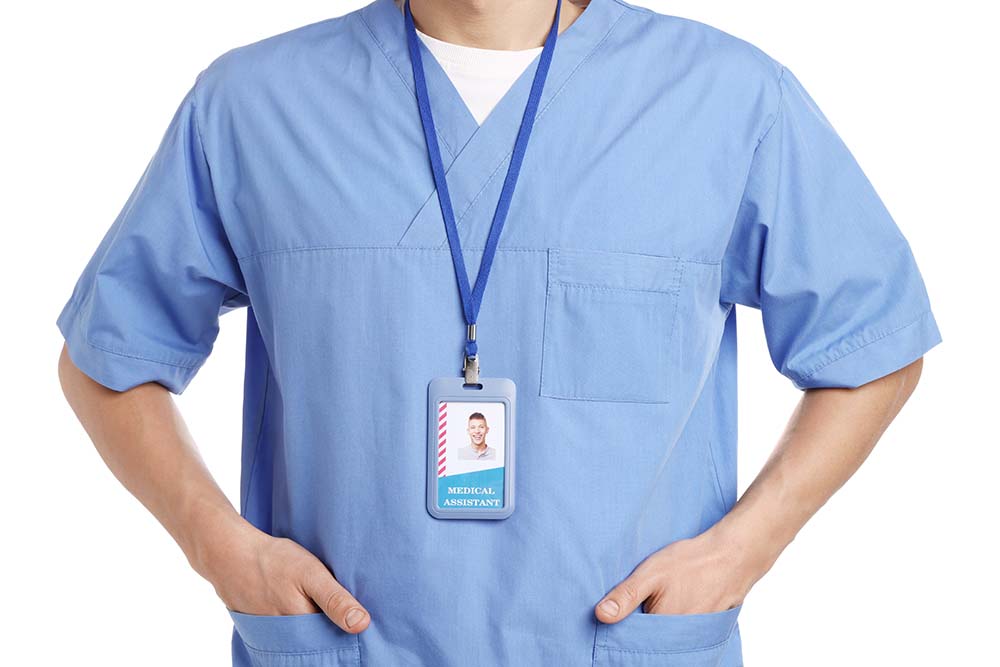 Medical assistant with badge on white background, closeup